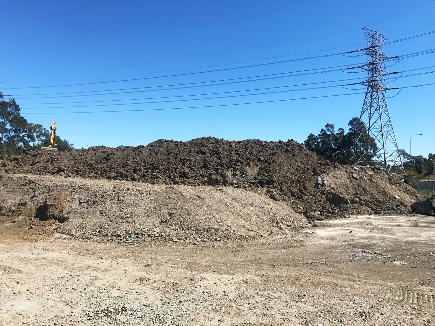 A large stockpile beside high-voltage transmission infrastructure